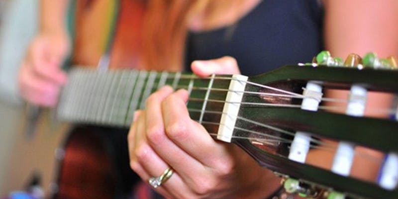 Woman's hand playing guitar