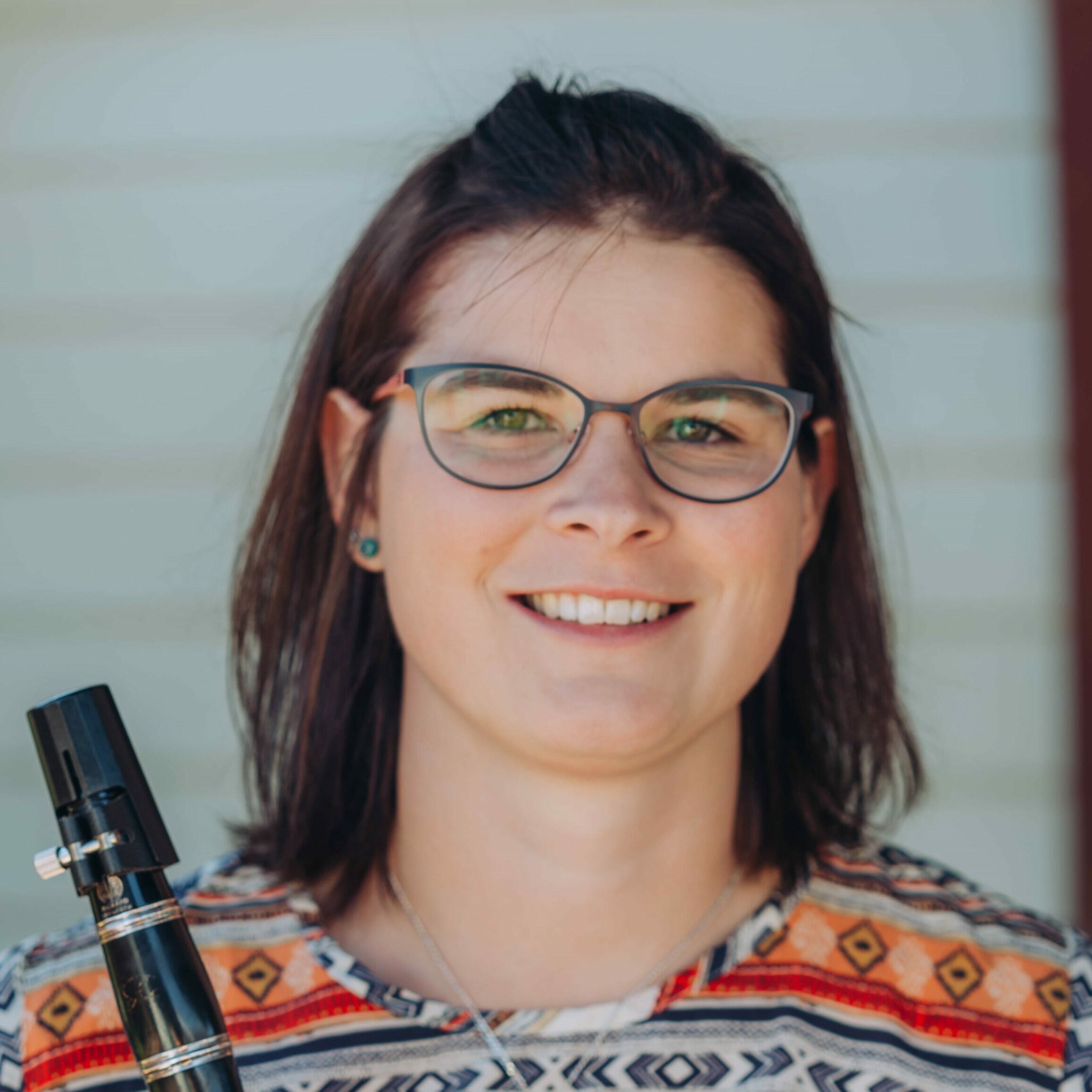 A peron smiling and holding a clarinet