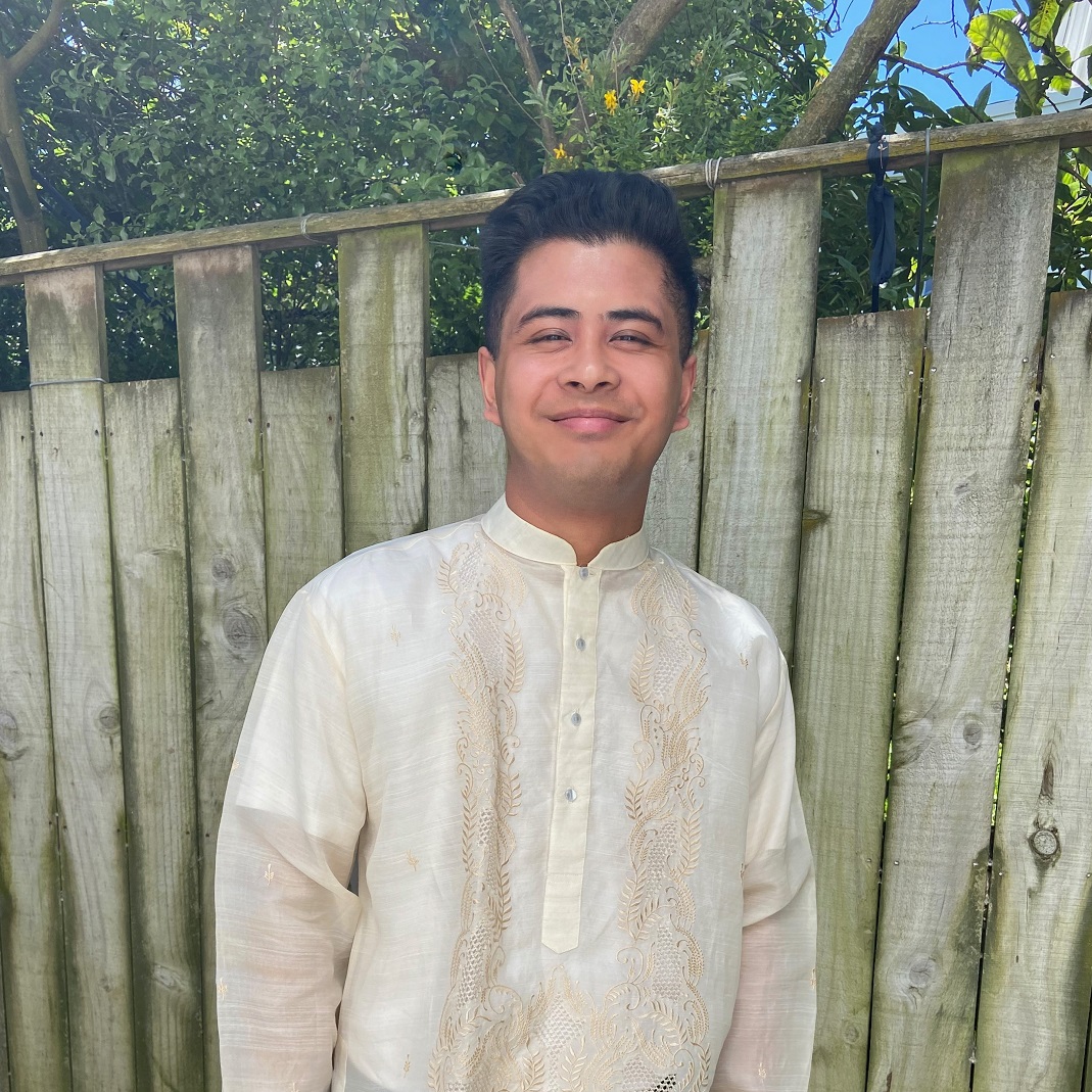 TJ Henrandez smiling in front of a wooden fence