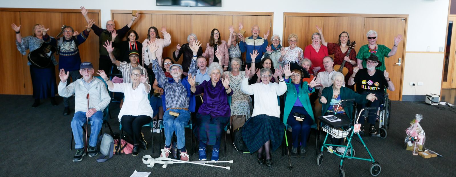 A group of people waving and smiling at the camera