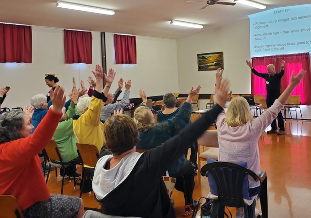 Brainwave Singers, arms in the air, warming up